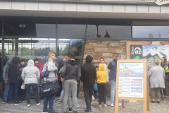 Ludzie stoją przed wejściem do budynku